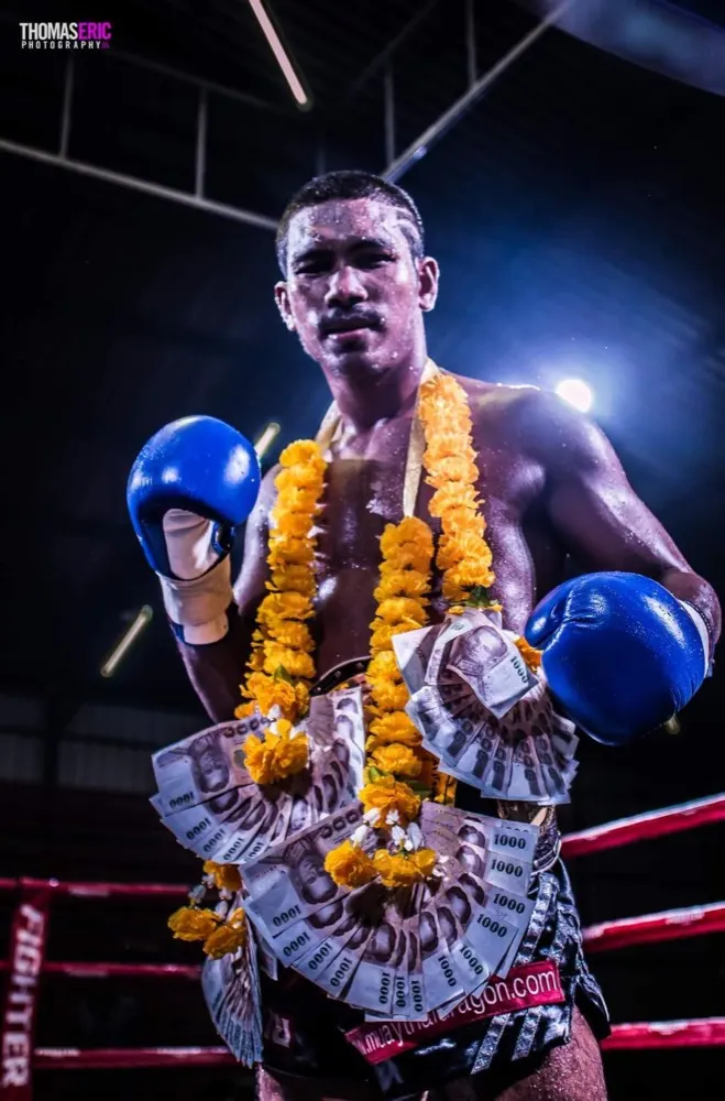 Kru Marn celebrating a fight victory in the ring — former Southern Thailand Champion